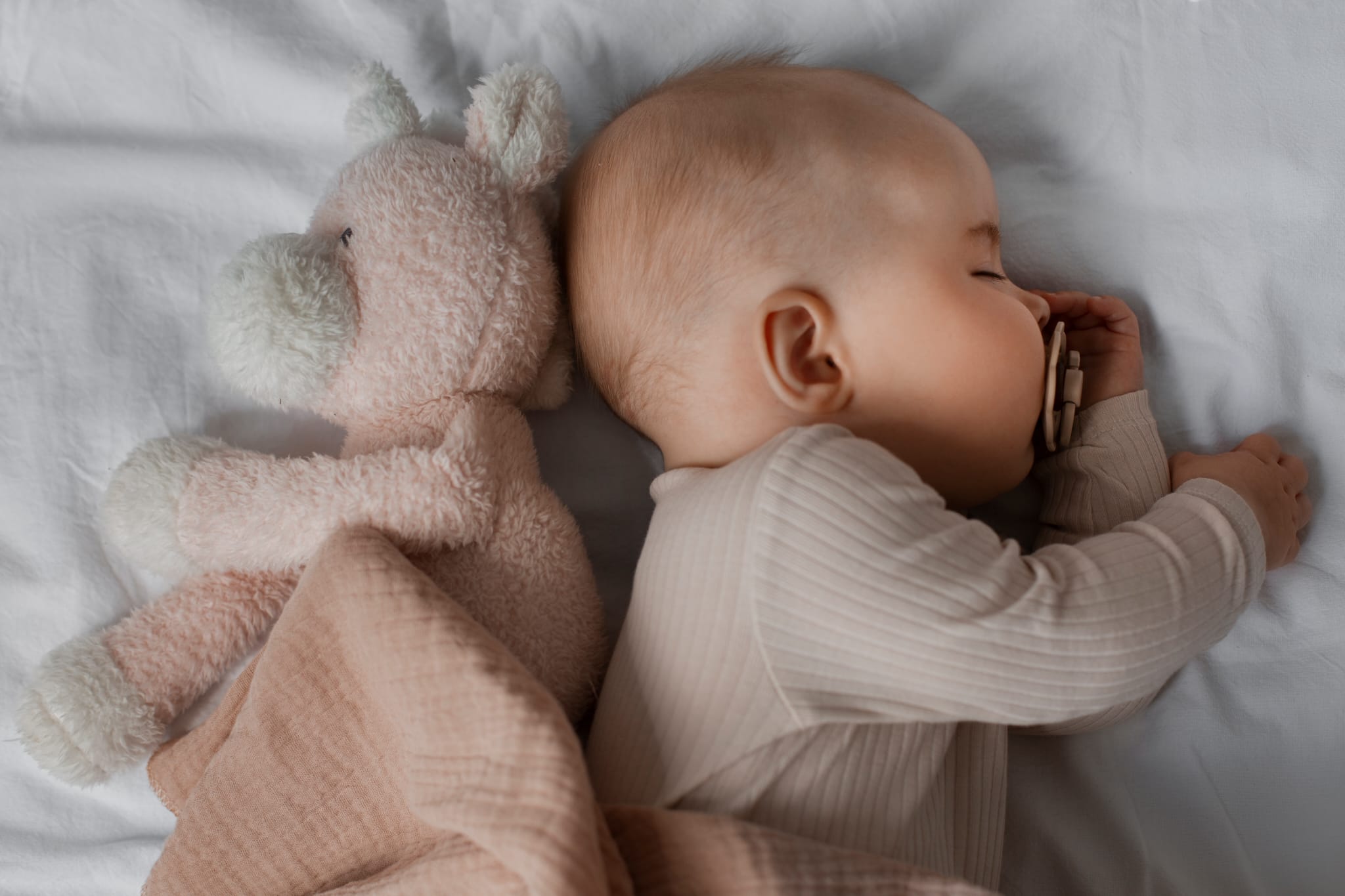 Bébé endormi paisiblement avec son doudou — coaching sommeil pour bébé et enfant